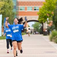 Participant nearing finish line with arms in the air